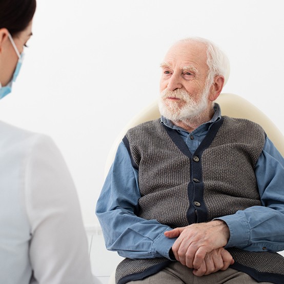 Senior patient listening attentively to dental team member