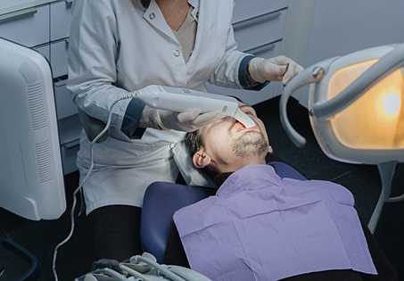 Dental team member capturing digital impression of patient’s mouth