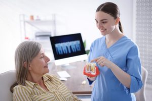 Patient and dental team member talking about dental implants 
